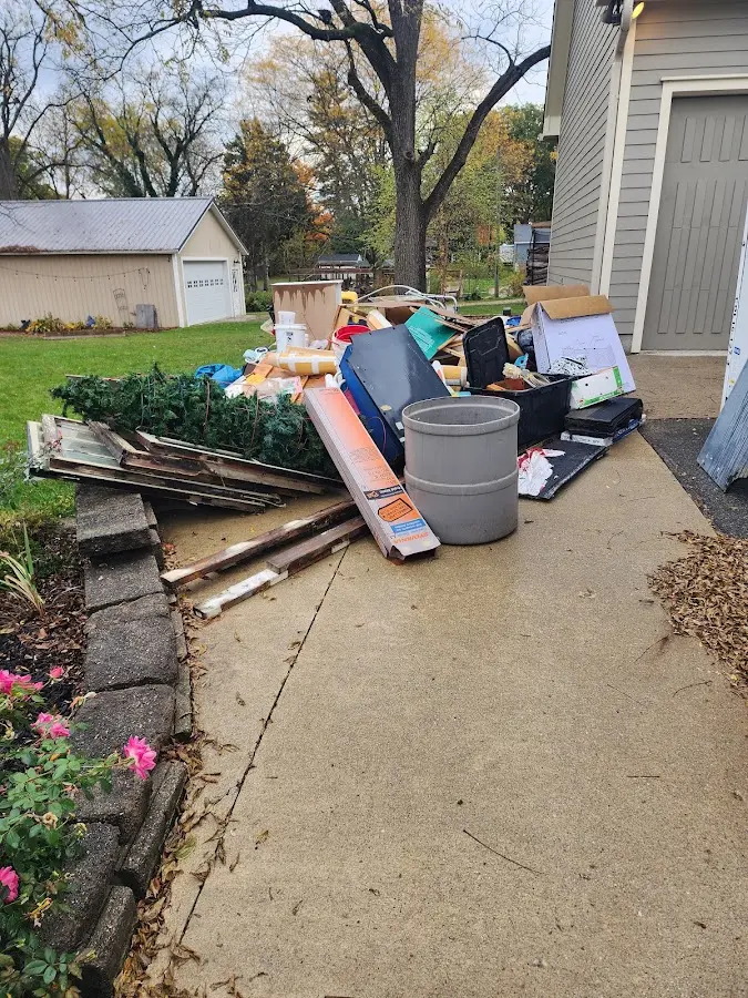 Dumpster being loaded with debris for 12 Yard Dumpster Rental in Fenton